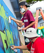 Paint project three men spray paining a wall